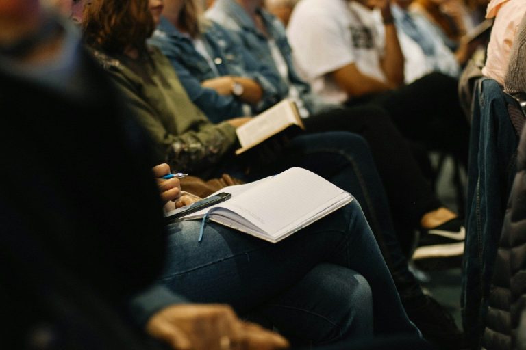 Seminare Eine Gruppe von Seminarteilnehmern folgt konzentriert dem Seminar.